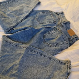 Blåa högmidjade jeans  - Blåa högmidjade jeans, från ginatricot, stretchiga strl. 36. Vida ben och dragkedja och knapp. 