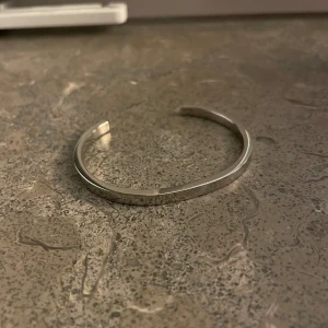 Armband  - Ett armband från Skultuna Mässingsbruk.  Har aldrig kommit till användning, du väljer storleken själv på armbandet genom o böja åt olika håll 