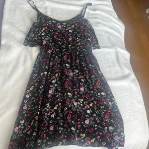Blommig klänning  - Säljer en söt svart klänning som är perfekt till vardags på sommaren. Den är bara använd ett fåtal gånger men ser ut som ny, den kommer dock inte till användning. 