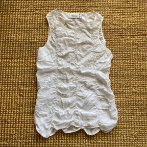 Vit topp från Weekday - En vit linnetopp från Weekday med rynkade detaljer. Toppen är ärmlös och har en kjedja på sidan 🎀 Säljer pga lite för stor för mig. 