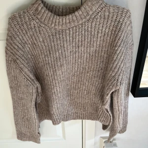 Brun/beige stickad tröja - Säljer denna jätte mjuka brun/beige stickade tröjan ifrån ginatricot! Den har slitts på sidorna och nere vid ärmarna. Nyskick eftersom att den knappt är använd. Perfekt nu till hösten🤍