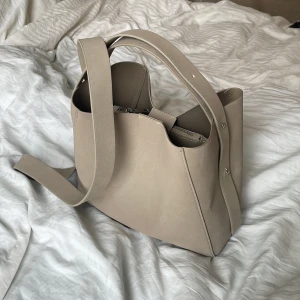 Handväska - Säljer denna beiga handväskan ifrån Ginatricot! Mellanstorleken och sällan använd! I materialet mocka🩷Tryck gärna på köp direkt!