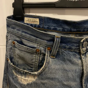 Levis 551 Jeans - Gråa/ljusblåa 551 jeans med slitningar från Levis, storlek W31L32. Säljer då storleken inte passar mig, annars inga skador. 9/10 skick!