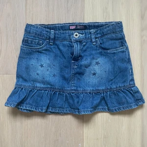 Jeanskjol med volang - Denna jeanskjol med volang. Märket är Levi’s men är i barnstorlek så liten. Midjemåttet är 32cm