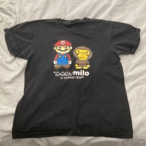 Baby milo t-shirt - tröjan har bra skick och trycket är inte skadat något. Jag vet ej om det fanns en lapp i tröjan men när jag fick den så fanns det ingen. Det står ingen storlek i tröjan men skulle säga att det är runt M.