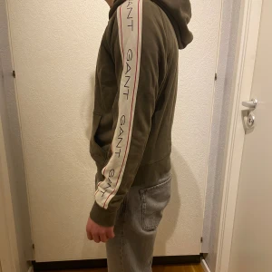Gant Hoodie - En grön hoodie från märket Gant! Är i använt skick men utan någon som helst defekter. Storlek 170. Hör av er vid frågor!
