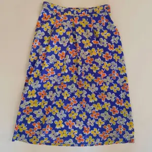 Vintage Purple Floral Printed Skirt w frontal pleating. Side Button and Zip Closure. Some color transfer in a white area, not visible when worn. Very Good Condition. Unlined. Best Fits M  Model is 160cm (5”3) and generally fits XS/S.  100% Silk