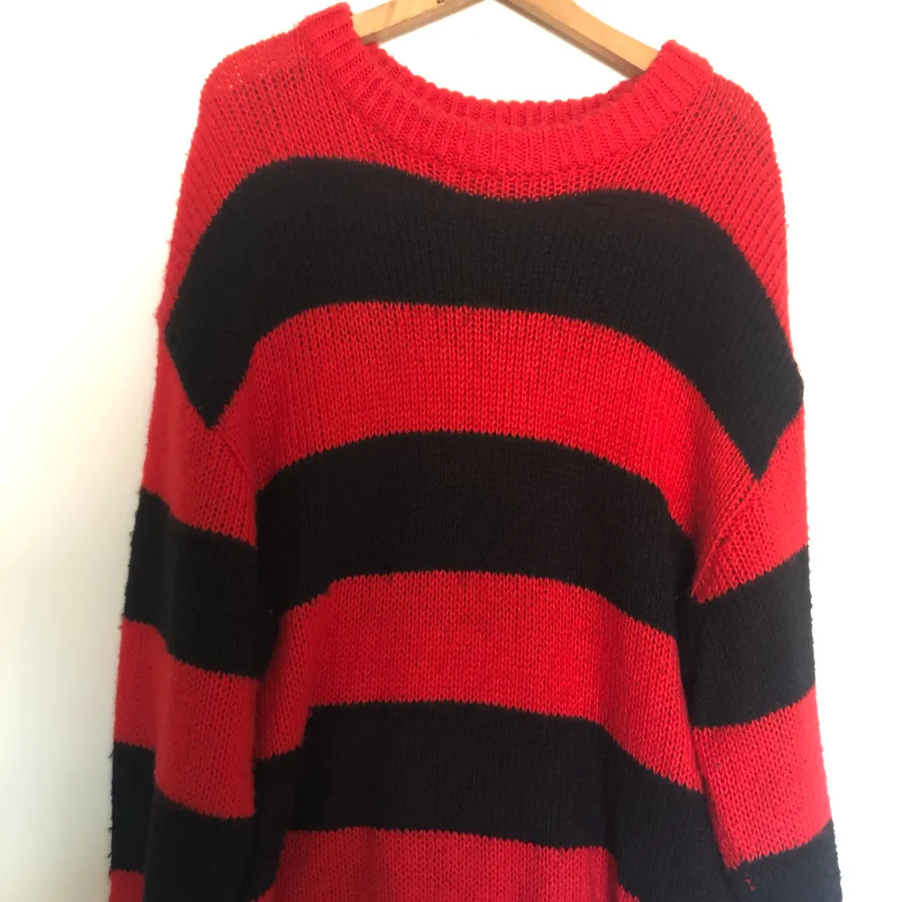 En röd svart stickad tröja. Den är storlek S och Oversized.. Tröjor & Koftor.