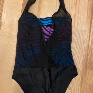 Jättefin baddräkt strl 38 - Baddräkt i mycket fint skick säljes.  Den har ett transparent tyg framtill över en färgglad botten som går upp i halternecks knytning. Strl 38. 