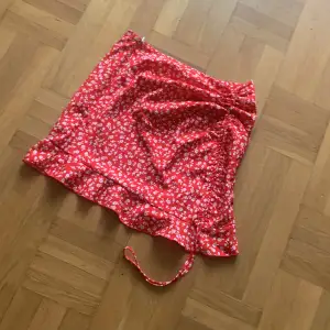 Röd kjol som har en tråd så man kan göra den kortare