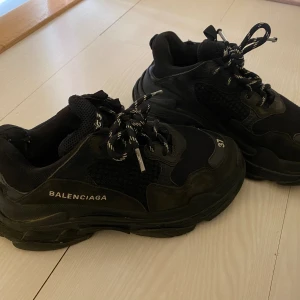 Balenciaga tripple s - Balenciaga tripple s, hel svart med vita detaljer.  Storlek 37, men stora i storleken så passar mig som har 38. Se bilder för skavanker på skorna.  Har många år kvar att ge!! 