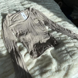 Långärmad topp - Långärmad topp med trumpetarmar från Gina tricot i storlek XS. Aldrig använd 