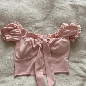 Off shoulder top - Off shoulder top med padding vid bysten. Behövs ingen bh. Är i ljus rosa. Aldrig används. Är cropped. 