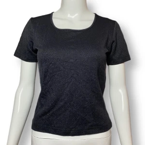 Glittrig 90s Top - 90s liknande glittrig topp från Popcorn.com. Stretchig material. Finns ej storlek, materiallapp har klippts av. MÅTT: Axel till axel 35.5cm, ärmlängd 18cm, armhåla till armhåla 43cm & längd 50cm. 