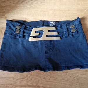 Vintage gold digga mini kjol - Väldigt fint skick bara att bältet har lite repor på sig. Storlek S passar liten M då den är stretchig dold dragkedja bak Säkerhetstrosor sydda   Midjemått 80-90 cm