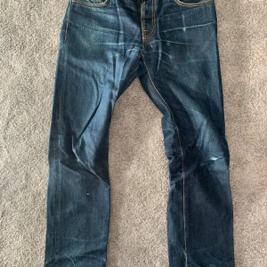Nudie Jeans Grim Tim - Grim Tim Dry Ring köpta 2017, ingångna, t tvättade <5 ggr. Skrev och vänster ficka lagade på Nudie i Malmö. Inte använda senaste 4 åren.  Ganska tight passform, passar kanske bäst nån som har 32-33 i midja annars.