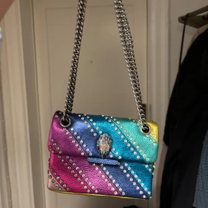 Kurt geiger väska  - Väskan är använd men i fint skick. Det enda felet på den är att den har små skavanker i vardera hörn & att lädret på baksidan är lite fläckigt.  Fråga gärna för fler bilder . 