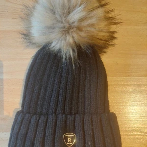 RockandBlue mössa, pom pom, svart, onesize - Ny utan prislapp, ull och akrylblandning, nypris 399 kr