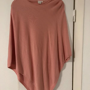 Rosa poncho  - En sparsamt använd rosa poncho i onesize