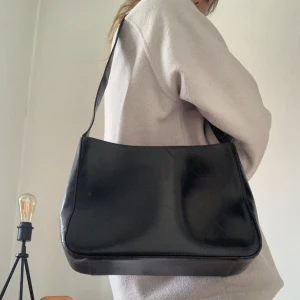 VÄSKA - Svart skinn väska, funkar både hängandes på axeln och crozbody! Frakt tillkommer. Skriv för mer info!  