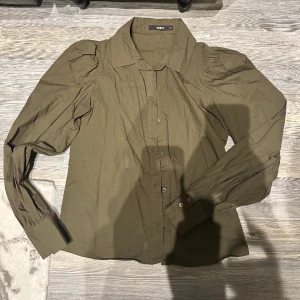 Militärgrön skjorta - Militärgrön skjorta i jättefint skick, lite puffiga ärmar