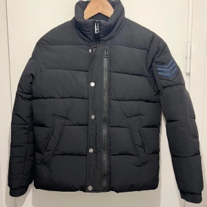 Zadig & Voltaire Kids Dano dunjacka strl 12 år (xs) - Ytterplagg, stl. 146/152 (10-12 år), Unisex Varm höst och vinterjacka från kids. Väldigt fint skick. Nypris 2100kr - Svart - Integrerad tunn luva som göms i en ficka på insidan av jackan  - Dragkedja och knappar, går att ta av delen med knappar 