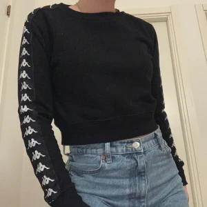 Kappa croppad sweatshirt  - Sjukt snygg kappa croppad sweatshirt i storlek XS för 80kr+frakt! Passar även mig som är mellan S-M. Knappast kommit till användning. Kappa märket har trillat av från bröstet, därav priset (men inget man känner saknas) 