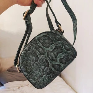 Grön axelväska i krokodilmönster - Väska från Prettylittlething i PU-läder. Väskan är i gott skick och axelbandet går att justera✨ 