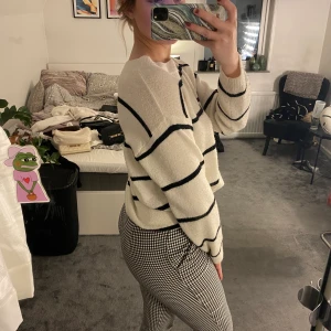 Vit stickad tröja med svarta ränder - Storlek XS men oversized. Smått nopprig vid exempelvis ärmen men de går o fixa till. Fint skick annars inga fläckar eller liknande. Frakt: 52kr 🚚💜