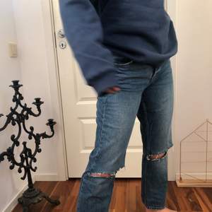 Ett par blåa jeans från Gina tricot med klippta hål på knäna🥰 Sparsamt använda och är i strl 42 men skulle säga att de passar 40 mer!