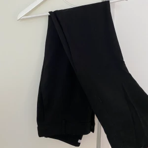 Svarta kostymbyxor  - Svarta kostymbyxor från H&M i storlek 36. Aldrig använda då dom är för låga i midjan för min smak. I helt nytt skick. Tyvärr jättesvårt att ta rättvis bild på dessa byxor. Dom är raka i benen och har en tight fit. ✨