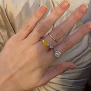 Multicolored ring - En super gullig liten ring i olika färger med en gul liten pärlblomma i mitten. Super söt och passar till typ allt! Gjord av mig, vill du ha en annan färg kombination så är det bara att skicka en beställning! 💖