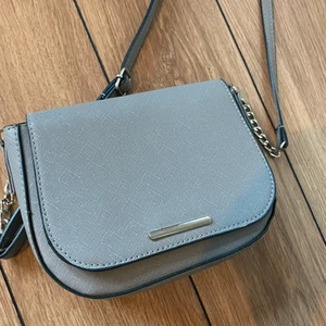 Grå väska - Grå väska med silvriga detaljer. Det är inget märke för har köpt den utomlands. Den är använd några gånger men ser ny ut. ❤️