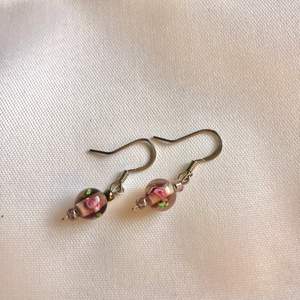Handgjorda örhängen med rosa glaspärlor. Aldrig använda.