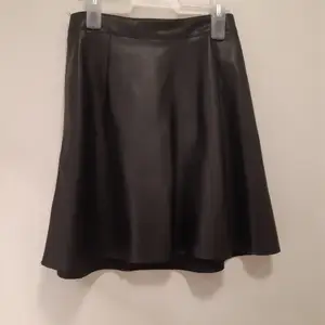 Svart kjol i skinnimitation i storlek xs, använd en gång, säljer då kjolen är förliten
