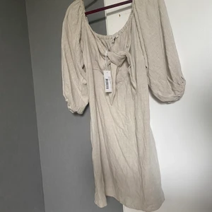 NLYTREND off shoulder klänning - Säljer en fin oanvänd off shoulder klänning i linne material. Dragkedja på sidan. 