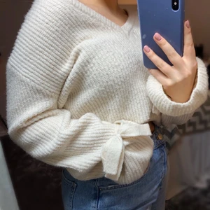 Stickad tröja - V-ringad stickad tröja från NA-KD med knyten/rosetter vid handlederna. Storlek XXS, stor i storleken, mer åt S hållet!