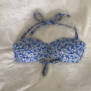 Bikinitopp - Oanvänd bikinitopp med avtagbara band så den funkar som en bandeautopp istället. Knytning både i ryggen och i nacken annars. Köparen står för frakten, kan annars mötas upp i Stockholm.