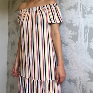 Randig klänning - Säljer min randiga, flerfärgade klänning från Ginatricot. Funkar både att ha ”overshoulder” eller ”undershoulder”. (Den går över knäna)💛🧡🖤