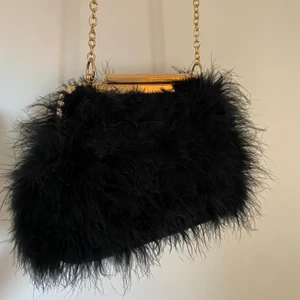 Svart Fluff väska - Säljer denna svarta fjäderväska från River Island då den inte kommer till användning längre. Möts upp i Västerås och eventuellt Stockholm. Betalning via Swish.💕