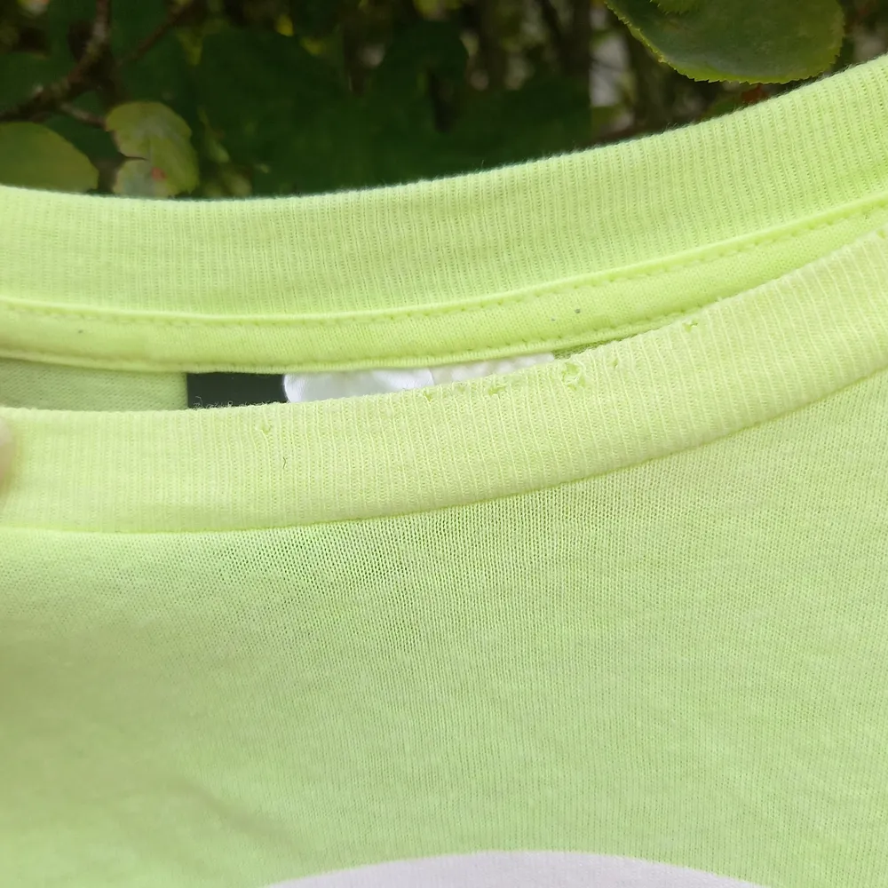 En neongul fanta lemon tröja från H&M. Perfekt för någon som gillar fanta! Använd några gånger, dock fick mkn kanin tag på tröjan en gång och rev upp lite (se bild 2) annars i perfekt skick! Säljs för 20 kr + frakt :). T-shirts.