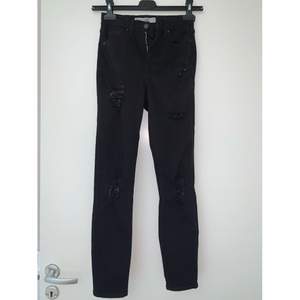 Ett par svarta slita jeans från Topshop Moto Jamie i storlek W25. 