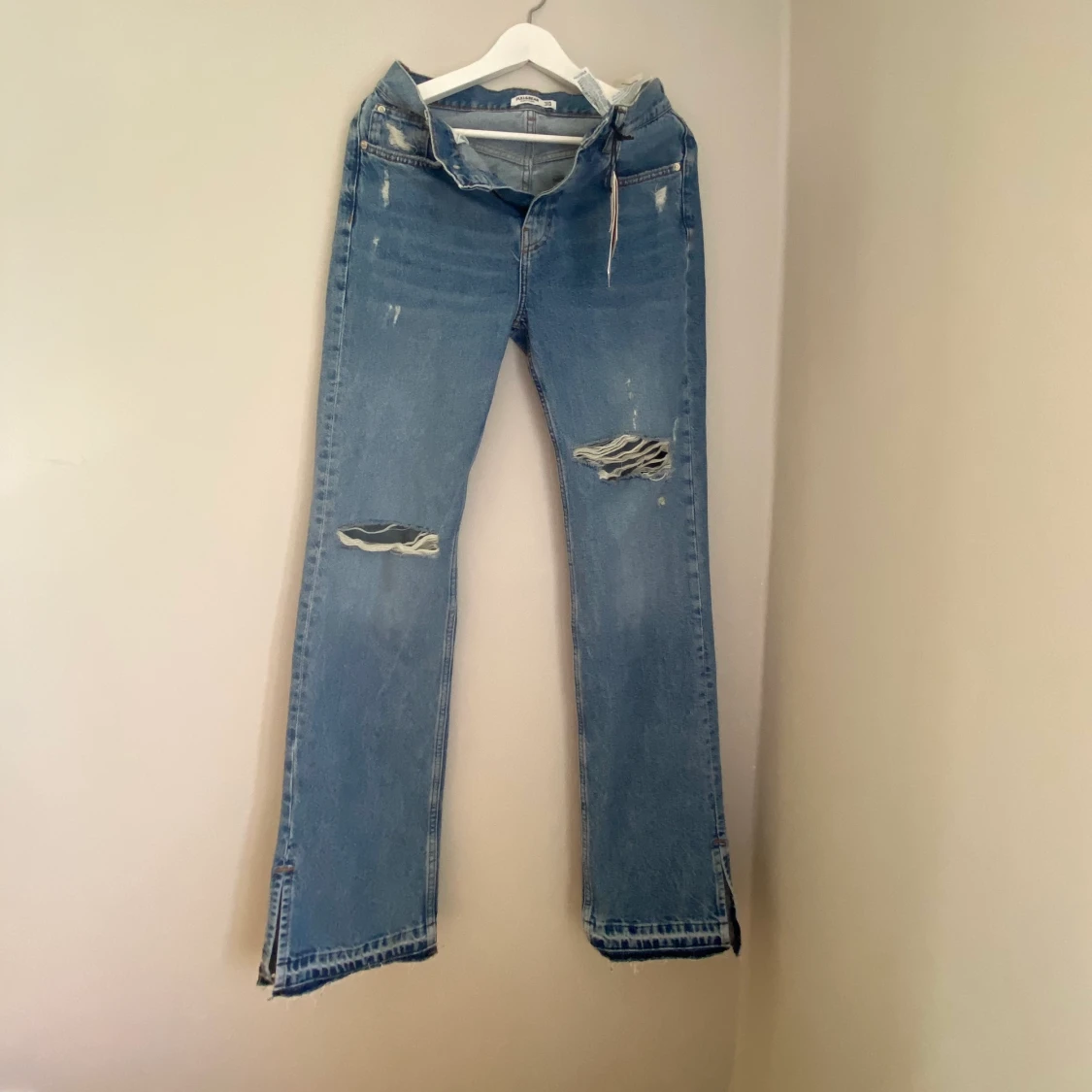 Oanvända slitna jeans med slits