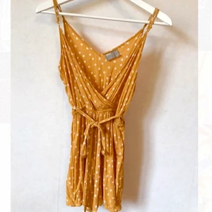 Gul playsuit, Asos, XS - Underbar senapsgul och prickig byxdress från Asos i något slags ”creppat” tyg, drapering och knytning i midjan (bak eller fram går att välja)..  Storlek 36, men tycker den likväl funkar för 34. 100% viscose. XS eller S.  Kan mötas i Stockholm eller skicka mot fraktkostnad! ✨🌸✨