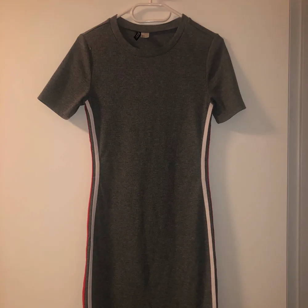 Grå klänning i storlek 40 från H&M! Bekväm längd men relativt kort, har två vita och röda ränder på sidan! Otroligt skönt material!. Klänningar.