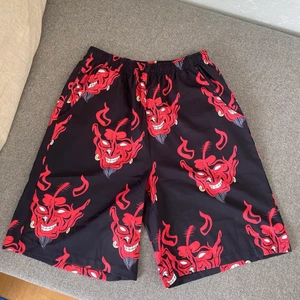 Shorts djävuls huvud  - Coola sommar shorts med populär design. Aldrig använda! Storlek S/M män. Fickor fram och bak. Frakt 24kr eller hämtas upp i Malmö. 