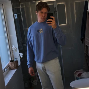 Vintage Sweatshirt Blå - !Oanvänd!  Blå Vintage Sweatshirt i oversize med grafisk logga baktill gjord på mjukt sweatshirttyg. Stilig och bekvämlig. Yttermaterial: 100% bomull