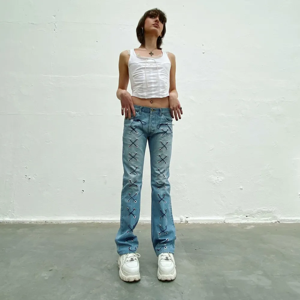 Lee secondhand-jeans med mörkblå snörning. Designade av Ezzie i samarbete med Ebba Martin. (Shipping only within Sweden). Jeans & Byxor.