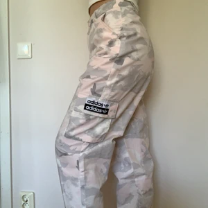 Rosa Adidas Byxor - Säljer dessa ljusrosa Adidas cargo byxor då de är lite för stora, de är i nyskick och är knappt använda 💘 Skönt material och rymliga fickor!🤩 De är high waist och storlek S. Nypris ca 500kr