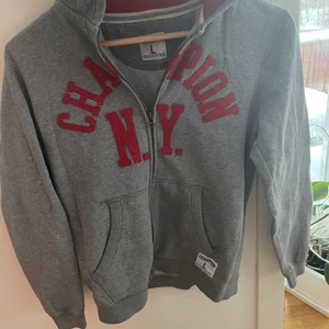 CHAMPION NY ZIP-HODDIE - Säljer min champion NY zip-hopdie! Går inte att få tag på längre! Är strl L i barn, men som i S i vanliga strl! Säljer billigt då jag behöver pengar och rensar mina kläder🥰 Jätte fint skick!